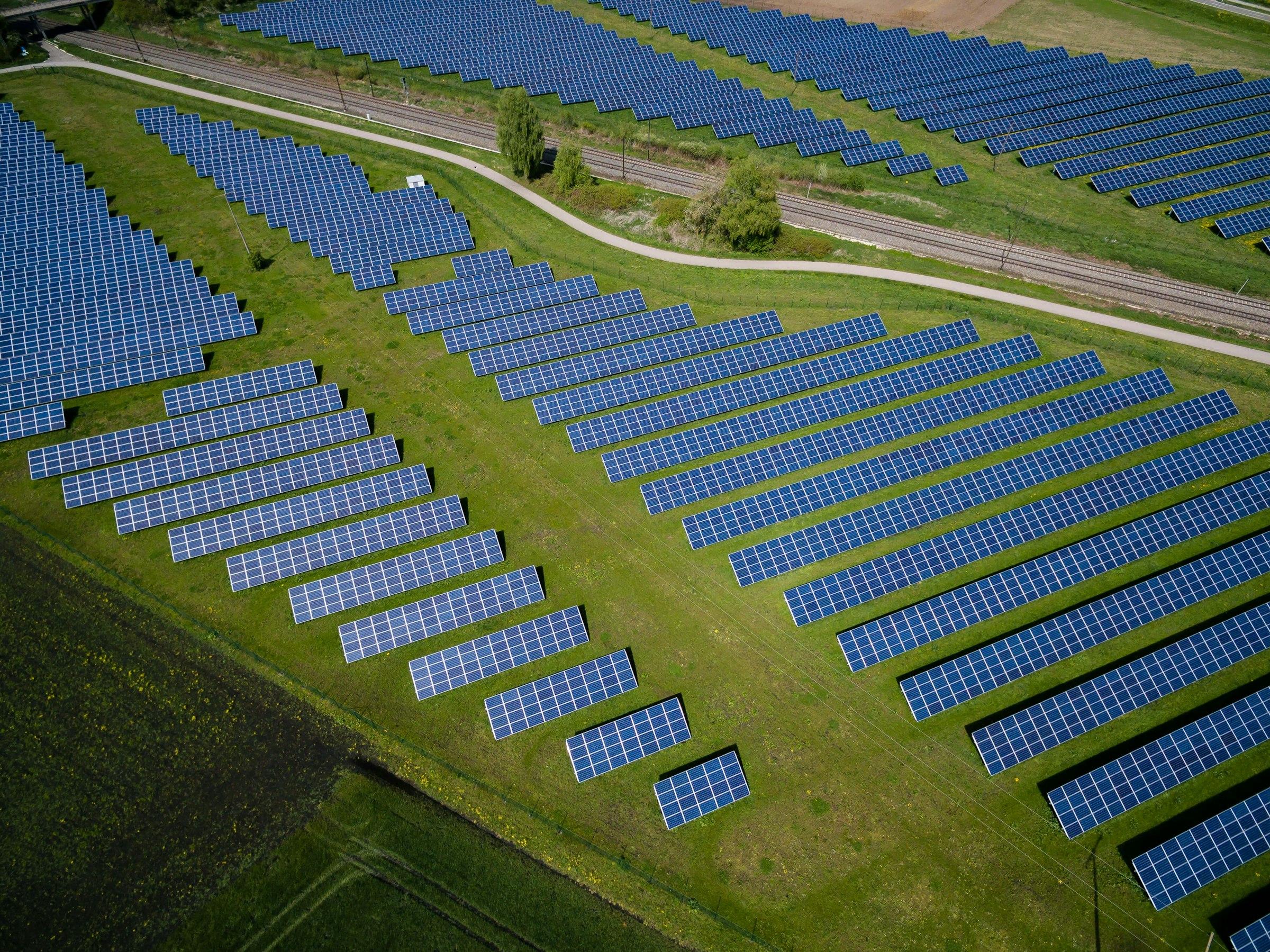 Aerial view of a solar farm among green fields.