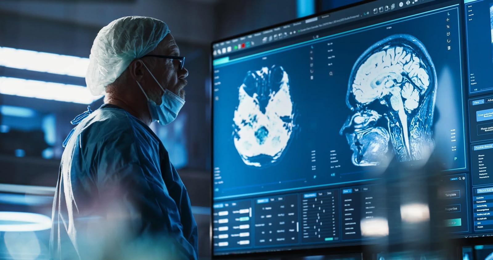 A clinician reviewing brain MRI scans on a large diagnostic display.