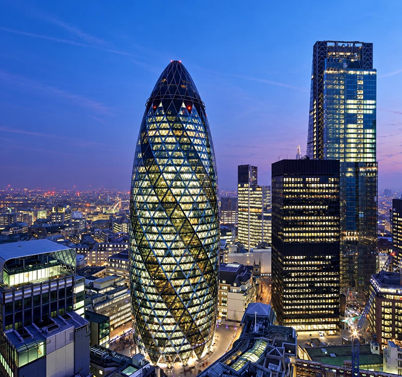 30 St Mary Axe — the Gherkin — lit at dusk in the City of London, home of our registered office.